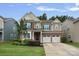Charming two-story home featuring a brick and siding facade, well-manicured lawn, and a two-car garage at 131 Cherry Bark Dr, Mooresville, NC 28117