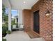 Inviting front porch features brick siding, decorative seating, and a charming welcome mat at 131 Cherry Bark Dr, Mooresville, NC 28117