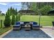 Inviting outdoor patio with cozy sectional, umbrella, and manicured lawn perfect for relaxation and entertaining at 131 Cherry Bark Dr, Mooresville, NC 28117