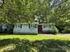 Charming single-story house with brick facade, complemented by lush greenery and ample shade trees at 1317 Moretz Ave, Charlotte, NC 28206