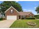 Charming brick home features a well-manicured front yard and attached garage at 133 Fontanelle Dr, Mooresville, NC 28115