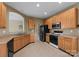 Kitchen with tile floors, wood cabinets, black appliances, and plenty of counter space at 133 Fontanelle Dr, Mooresville, NC 28115