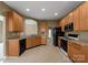 Functional kitchen layout with warm wood cabinets, black appliances, and open access to living areas at 133 Fontanelle Dr, Mooresville, NC 28115