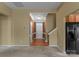 Inviting open-concept living area featuring neutral carpet, a staircase, and an adjacent kitchen view at 133 Fontanelle Dr, Mooresville, NC 28115