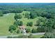 Aerial view of a home and barn on a property surrounded by open pastureland and many mature trees at 157 Blackberry Ln, Taylorsville, NC 28681