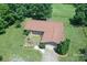 Aerial view of a brick home featuring a brown roof, garage, and brick patio in a grassy, tree-lined yard at 157 Blackberry Ln, Taylorsville, NC 28681