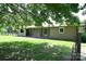 Backyard view of brick ranch home with patio and fenced-in area surrounded by lush trees at 157 Blackberry Ln, Taylorsville, NC 28681