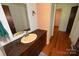 Bathroom features a single vanity with an inset sink, dark cabinets, and wood flooring at 157 Blackberry Ln, Taylorsville, NC 28681