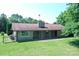 Rear exterior view showing brick ranch home with manicured lawn and long covered porch at 157 Blackberry Ln, Taylorsville, NC 28681