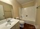 Bathroom features a tub-shower combination, white vanity, and neutral color scheme at 1600 Sharon W Rd # 16, Charlotte, NC 28210
