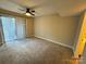Carpeted bedroom with ceiling fan, sliding glass doors, and ample closet space at 1600 Sharon W Rd # 16, Charlotte, NC 28210
