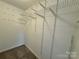 Walk-in closet with adjustable white wire shelving for organizing clothing, shoes, and accessories at 1600 Sharon W Rd # 16, Charlotte, NC 28210