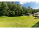 A lush green backyard with storage shed backed by mature trees at 1675 Old Lynwood Cir, Lancaster, SC 29720