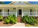 Close-up of a house with a black front door, brick steps, and lush green plants at 1675 Old Lynwood Cir, Lancaster, SC 29720