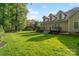 Lush backyard with green grass and mature trees and large deck, perfect for outdoor activities at 1812 Mill Chase Ln, Waxhaw, NC 28173