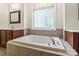 Close up of the bathtub with tile surround, chrome hardware, and a tiled window at 1812 Mill Chase Ln, Waxhaw, NC 28173