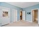 Bright blue bedroom with access to bathroom, and door leading to the outside at 1812 Mill Chase Ln, Waxhaw, NC 28173