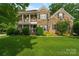 Charming two-story brick home with a well-manicured lawn, classic columns, and dark shutters at 1812 Mill Chase Ln, Waxhaw, NC 28173