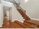 Elegant foyer with hardwood floors, staircase with dark iron spindles, and a view of the fireplace at 1812 Mill Chase Ln, Waxhaw, NC 28173