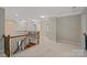 Upstairs hallway with natural lighting, neutral carpet, and beautiful wrought iron at 1812 Mill Chase Ln, Waxhaw, NC 28173
