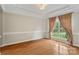 Bright living room featuring hardwood floors, large window with detailed trim, and elegant crown molding at 1812 Mill Chase Ln, Waxhaw, NC 28173