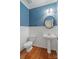 Stylish powder room featuring a pedestal sink, wood floors, and decorative wall accents at 1812 Mill Chase Ln, Waxhaw, NC 28173