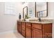 Bathroom featuring double vanity with granite countertops, framed mirrors, and modern fixtures at 18236 Coulter Pkwy, Cornelius, NC 28031