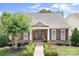 Charming single-story home featuring stone accents, manicured landscaping, and a welcoming front porch at 18236 Coulter Pkwy, Cornelius, NC 28031