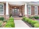 Up-close front exterior of a stone-accented home featuring a beautifully decorated porch and manicured landscaping at 18236 Coulter Pkwy, Cornelius, NC 28031