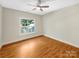 Cozy bedroom with hardwood floors, ceiling fan, and a bright window overlooking the yard at 2027 Brook View Ct, Matthews, NC 28104