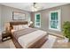 Comfortable bedroom with a ceiling fan, two windows, and a plush rug at 2027 Brook View Ct, Matthews, NC 28104