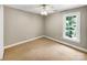 Comfortable carpeted bedroom with a ceiling fan and a window offering natural light at 2027 Brook View Ct, Matthews, NC 28104