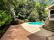 Inviting backyard pool surrounded by lush landscaping and a patterned concrete patio at 2027 Brook View Ct, Matthews, NC 28104