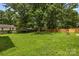 Large grassy backyard with mature trees, a wooden fence, and a swing at 2476 Cane Mill Rd, Lancaster, SC 29720