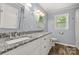 Updated bathroom featuring a double vanity with granite countertop, modern fixtures, and wood look floors at 2476 Cane Mill Rd, Lancaster, SC 29720