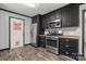 Updated kitchen featuring stainless steel appliances, black cabinetry, and durable wood-look floors at 2476 Cane Mill Rd, Lancaster, SC 29720
