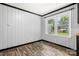 A cozy room features wood-look floors, light gray walls with black trim, and natural light from a double window at 2476 Cane Mill Rd, Lancaster, SC 29720