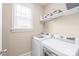 Well-equipped laundry room featuring modern washer and dryer units, with overhead storage and a bright window at 257 Auburn View Rd, Rock Hill, SC 29730