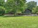 Large backyard featuring a well-maintained lawn, wooden deck with seating, and mature trees, offering a private outdoor space at 2915 Old Stage Rd, Gastonia, NC 28052