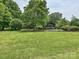 Large grassy backyard featuring mature trees and landscaping at 2915 Old Stage Rd, Gastonia, NC 28052