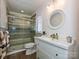 Bright bathroom with white vanity, decorative mirror, and glass-enclosed shower at 2915 Old Stage Rd, Gastonia, NC 28052