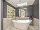 Freestanding white bathtub with stained glass window and built-in shelving with decorations at 2915 Old Stage Rd, Gastonia, NC 28052