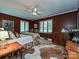 Red and brown bedroom with hardwood floors, ceiling fan, and two windows with blinds at 2915 Old Stage Rd, Gastonia, NC 28052