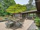 Wooden deck featuring an outdoor dining area with a bright green umbrella and a view of the wooded area at 2915 Old Stage Rd, Gastonia, NC 28052
