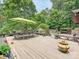 Spacious wooden deck featuring an outdoor dining area, bright green umbrella, and partial view of the pool at 2915 Old Stage Rd, Gastonia, NC 28052