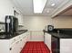 Functional kitchenette with white cabinets, dark countertops, and a classic red plaid carpet at 2915 Old Stage Rd, Gastonia, NC 28052