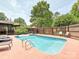 A private backyard pool surrounded by a red concrete deck and a wooden fence with artistic flower decorations at 2915 Old Stage Rd, Gastonia, NC 28052