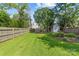 Large, grassy backyard with a wooden fence, garden area and storage shed at 3035 Florida Ave, Charlotte, NC 28205