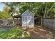 Close-up of backyard shed with covered area, adjacent garden, and mature trees at 3035 Florida Ave, Charlotte, NC 28205