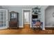 Hallway view showcasing hardwood floors, an antique cabinet, and a desk with a comfortable chair at 3035 Florida Ave, Charlotte, NC 28205